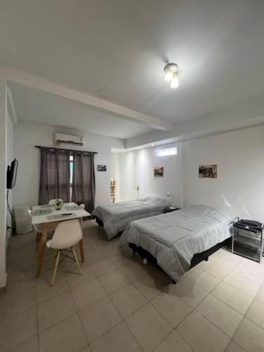 a bedroom with two beds and a desk and a television at Cálido dpto en pleno centro in Corrientes