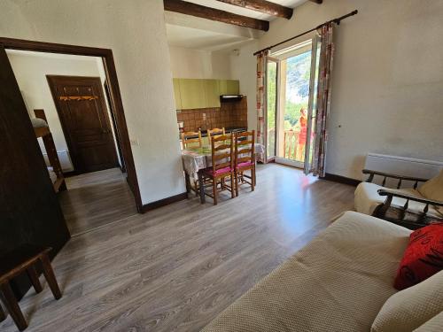 a living room with a couch and a table with chairs at Appartement La Meije in La Grave