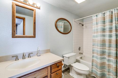 a bathroom with a sink and a toilet and a mirror at Beautiful Wasilla Home Rental with Deck and Gas Grill! in Wasilla