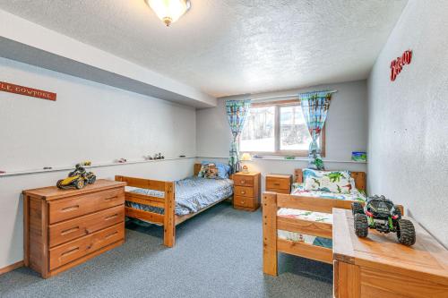 a room with a bedroom with a bed and a desk at Beautiful Wasilla Home Rental with Deck and Gas Grill! in Wasilla