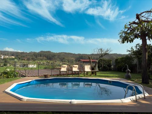 a swimming pool in a yard with a table and chairs at Olival House in Paço de Sousa