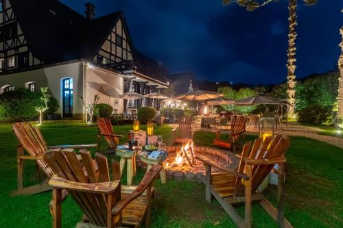a backyard with chairs and a fire pit at night at Ort Hotel in Campos do Jordão
