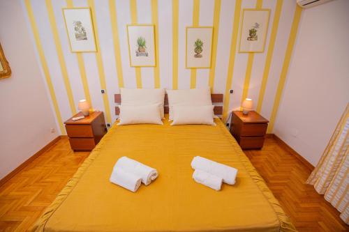 a bedroom with a yellow bed with two white pillows at Affitti Brevi Toscana - Villa Charme in Fonteblanda