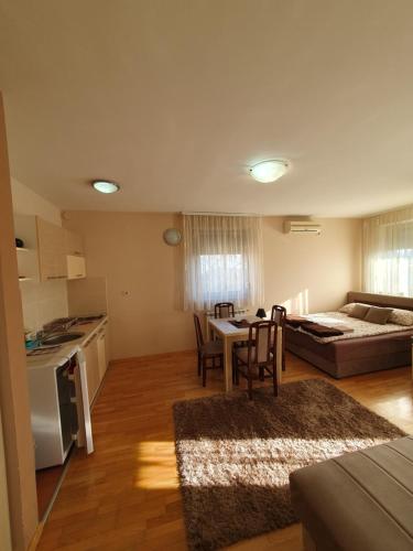eine Küche und ein Wohnzimmer mit einem Tisch und Stühlen in der Unterkunft Apartmani Kesten in Vrnjačka Banja