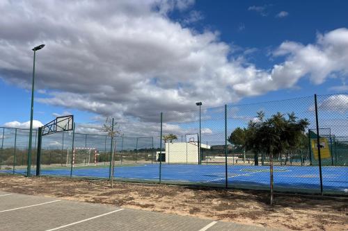 a tennis court with a fence and a basketball hoop at Casa Cristina, Corvera in Corvera