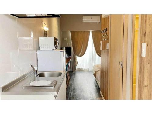 una pequeña cocina con fregadero y microondas en HYGGE biimata - Vacation STAY 06389v, en Nago