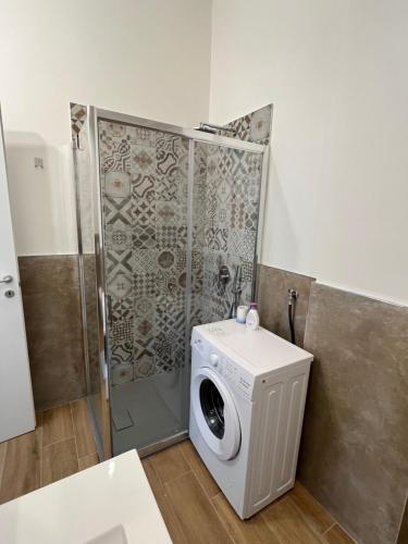 a washing machine in a bathroom with a shower at Mapa Holiday Sanremo 25 in Sanremo