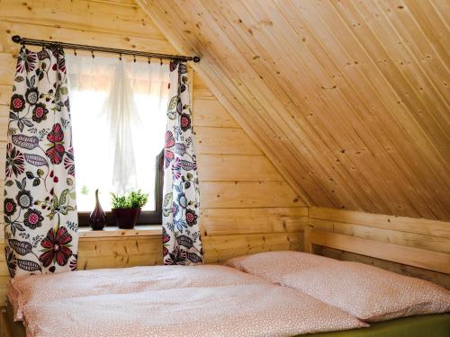 um quarto com uma cama num quarto com uma janela em Domki cało roczne z własnym stawem nad jeziorem em Ryn