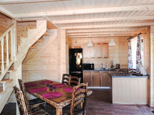 a dining room with a table and a kitchen at Domki cało roczne z własnym stawem nad jeziorem in Ryn