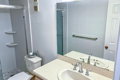 ein Badezimmer mit einem Waschbecken, einem WC und einem Spiegel in der Unterkunft Best of the Beach in Cedar Landing