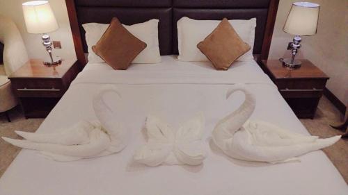 dois cisnes esculpidos numa cama num quarto de hotel em Marbella Residential Units em Riyadh