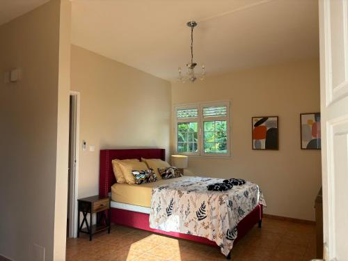 Schlafzimmer mit einem Bett und einem Fenster in der Unterkunft Villa Elise Jolie Maison , Piscine, WiFi, pour 7 personnes in Ducos