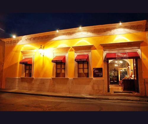 a yellow building with red awnings on a street at Casa de los Dulces Sueños in Morelia