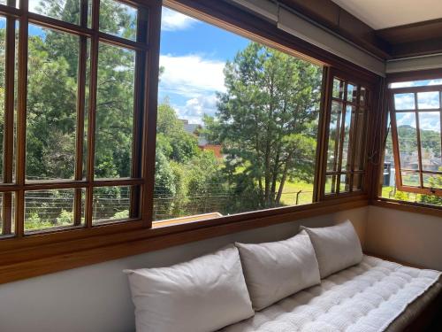 a window seat with a white couch in a room with windows at Apartamento Quinta da Serra - Canela in Canela