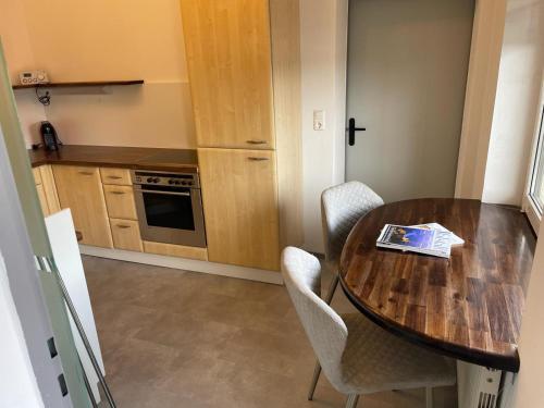 una pequeña cocina con mesa de madera y sillas en Apartment Paulberg, en Ardagger Stift