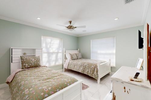 een slaapkamer met 2 bedden en een plafondventilator bij Little Pine Island Retreat in Hernando Beach
