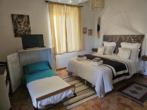 1 dormitorio con 1 cama y TV. en Chambre d'Hôtes LES ROCHES, en Corme-Royal