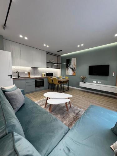 een woonkamer met een blauwe bank en een keuken bij Luxurious seaside apartment 1 in Durrës
