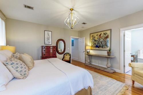 a bedroom with a white bed and a chandelier at Grove By The Sea: Passin' Thru in Santa Rosa Beach