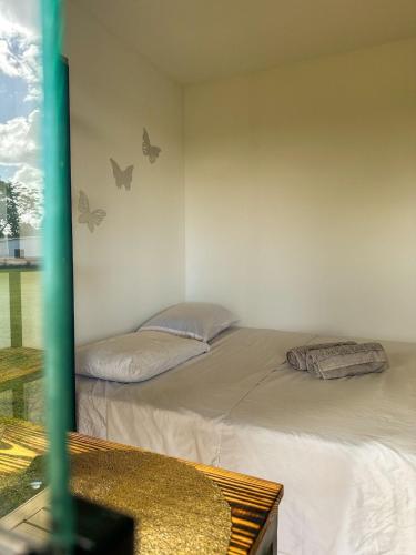 two beds in a room with butterflies on the wall at Cenário Perfeito para Seu Dia Especial: Chácara Recanto do Pinheiro in Capão do Leão