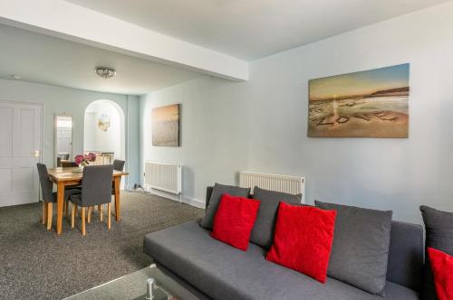 a living room with a couch and a table at Victoria Cottage-seconds to beach-pet friendly- easy parking- self check in-sleep 6 people-minutes walk to all amenities in Deal