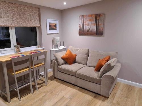a living room with a couch and a table at Rowan Bank Retreat in Fort Augustus