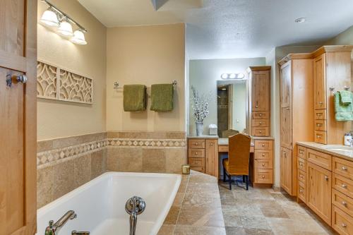 baño con bañera y lavabo y escritorio en Serene Nevada Retreat with Deck, Grill and Hot Tub!, en Stateline