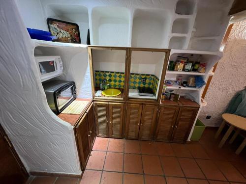 a small kitchen with wooden cabinets and a microwave at ALCAZABA CON VISTAS INCREIBLES in Sierra Nevada