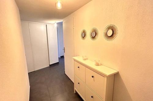 La salle de bains est pourvue de 2 miroirs sur le mur et d'une armoire. dans l'établissement 040- La Movida - Gare Sud de France * 2chambres, Piscine, Clim, 2Parking, à Lattes