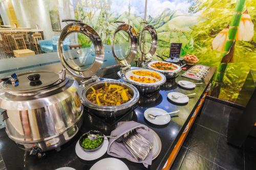 a buffet with several dishes of food on a table at GHL Hotel Abadia Plaza in Pereira