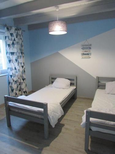 um quarto com 2 camas e uma parede azul em L'Étape Bourguignonne (proche Beaune et Chalon) em Sermesse