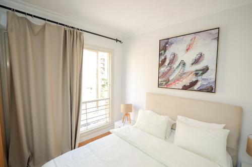 a bedroom with a white bed and a window at Cozy apartment New Cairo in New cairo