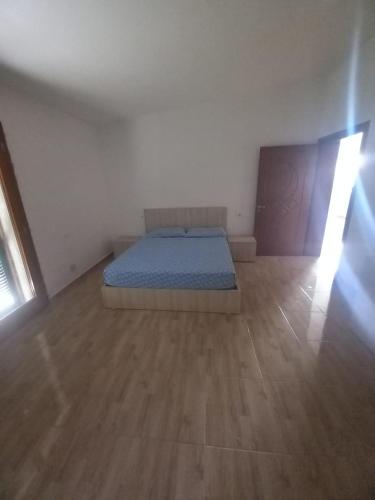 um quarto com uma cama e piso em madeira em Vila Toscana em Baks-Rrjoll