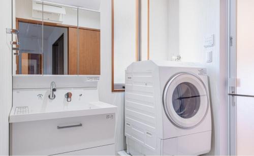 a white bathroom with a washing machine and a sink at Residential Voyan Minamisunacho - Vacation STAY 14988v in Tokyo