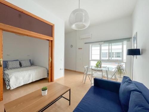 un soggiorno con letto e tavolo di Plz de la Merced Apartamentos Solera by Life in Malaga a Málaga