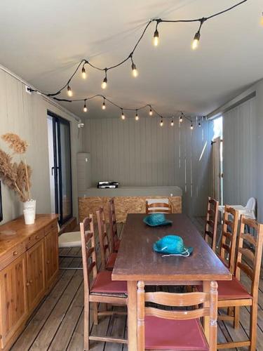 une salle à manger avec une table, des chaises et des lumières dans l'établissement Oasis Cove Côté Étang, accès baignade, proche plage, à Sète