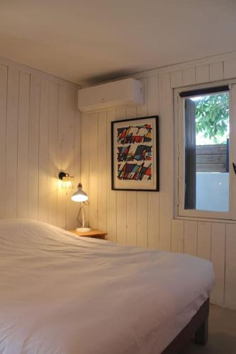 une chambre avec un lit blanc et une fenêtre dans l'établissement Oasis Cove Côté Étang, accès baignade, proche plage, à Sète