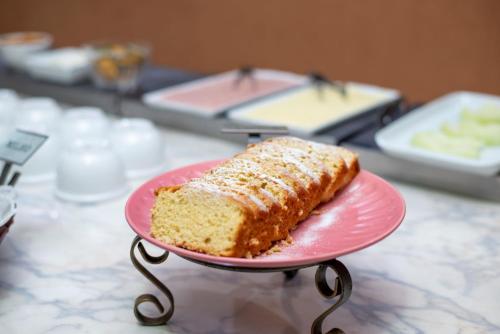 ein Stück Kuchen auf einem rosa Teller auf einem Tisch in der Unterkunft Smart Cataratas Hotel in Foz do Iguaçu