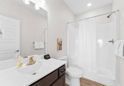 Un baño blanco con lavabo e inodoro. en Luxury Lakefront: 9BR/8.5BA, Views, Peak Comfort, en Branson