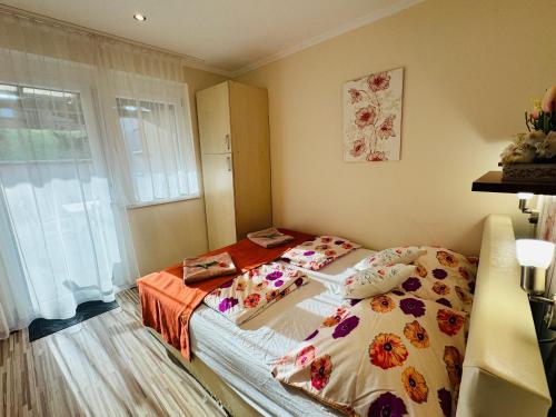 een slaapkamer met een bed met bloemen erop bij Oregano Apartmanok Siófok in Siófok