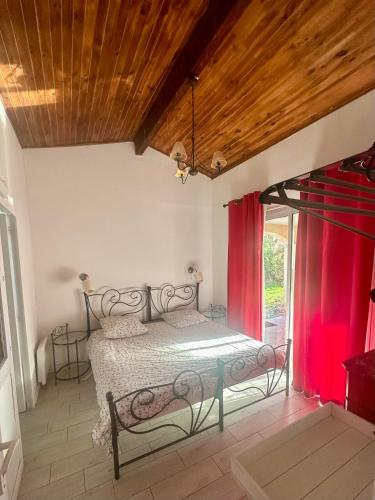 une chambre avec un lit et une fenêtre avec des rideaux rouges dans l'établissement Gite - maison de charme, à Saint-Vivien-de-Médoc