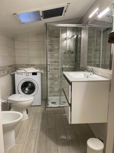 a bathroom with a toilet a sink and a washing machine at RESIDENCE VIOLA in Foggia