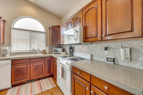 a kitchen with wooden cabinets and a white stove top oven at Large Colorado Springs Home with View of Pikes Peak! in Pikeview