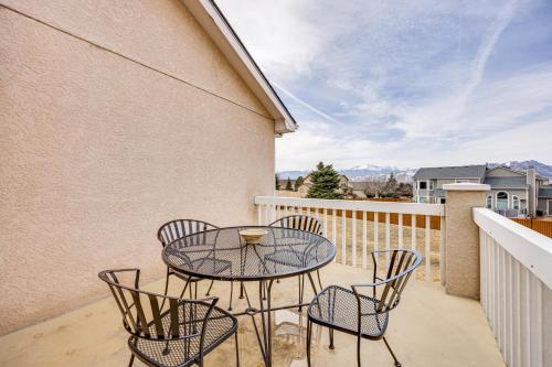 a patio with a table and chairs on a balcony at Large Colorado Springs Home with View of Pikes Peak! in Pikeview