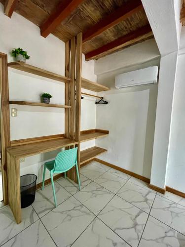 a room with a desk and a green chair at Casa Peregrina in Ayampe