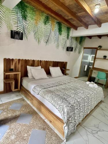 - une chambre avec un grand lit et une tête de lit en bois dans l'établissement Casa Peregrina, à Ayampe