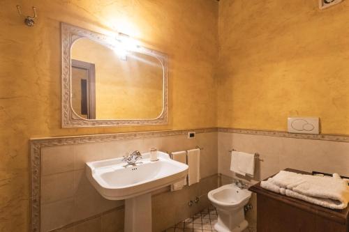 a bathroom with a sink and a toilet and a mirror at La Locanda dell'Ambra in Talamello