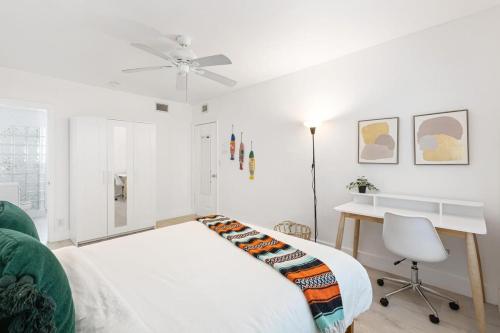 a white bedroom with a bed and a desk at Dreamy 1-bedroom apt walking distance to Las Olas in Fort Lauderdale