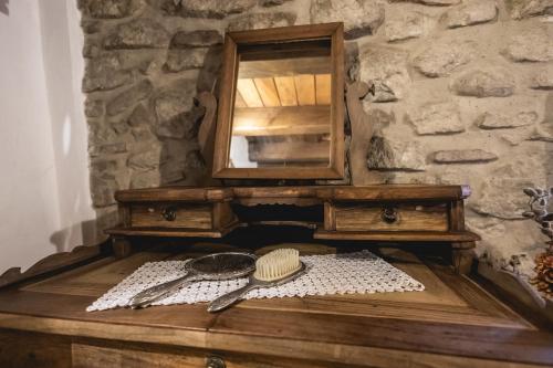 a wooden table with a mirror and a comb and brushes at La Locanda dell'Ambra in Talamello