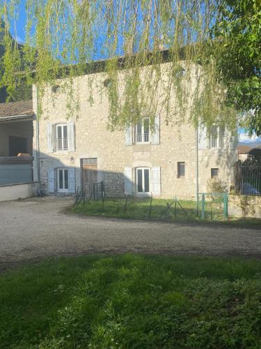 a large brick building with a fence in front of it at Chambres de la ferme du Brocey in Crolles